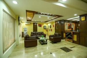 Sala de estar con 2 sofás y mesa en Hotel Abi's Inn, en Thanjāvūr