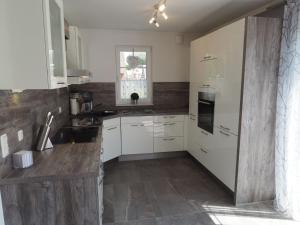 una cucina con armadietti bianchi e pavimenti in legno di Lively holiday home in Rerik with Garden a Rerik