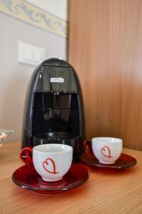 a coffee maker and two cups on a table at B&B AL VIALE in Foggia +18 photos