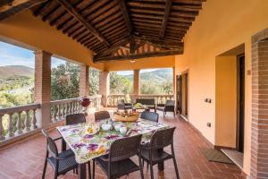 a dining room with a table and chairs on a balcony at Il Castagno Toscana in Campiglia Marittima