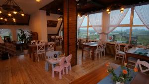 レンボルクにあるZajazd Kaszubskiのテーブルと椅子、窓のあるレストラン