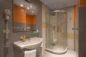 un bagno con lavandino e doccia di Hotel Mediterraneo a Livorno