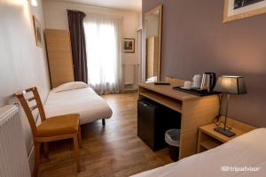 a hotel room with a desk and a bed at Hotel de L'Union in Paris