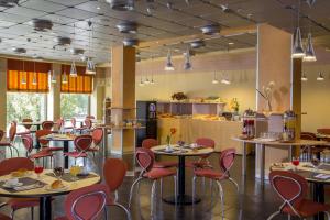 a restaurant with tables and chairs and a counter at Hotel Mediterraneo in Livorno