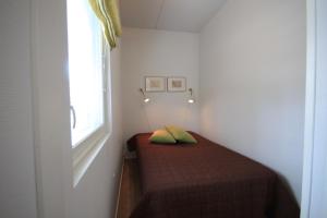 a small bed in a room with a window at Levillas Skimbaajankuja 6 as3 in Levi