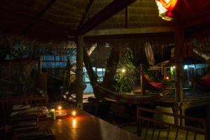 a room with a table with candles and a hammock at Sook Jai Guest House in Chiang Rai