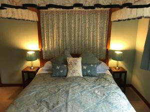 a bedroom with a large bed with two lamps at Drumbuie Farm B&B in Drumnadrochit