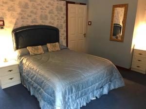 a bedroom with a bed with a blue comforter at Drumbuie Farm B&B in Drumnadrochit