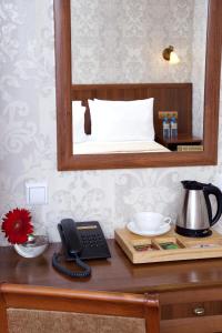 a desk with a phone and a mirror on a bed at Hotel Moyka 5 in Saint Petersburg