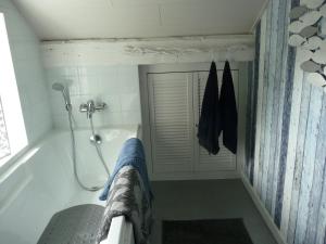 La salle de bains est pourvue d'une baignoire avec douche et d'un rideau de douche. dans l'établissement Autrefois chez Lina, à Dinant