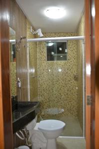 uma casa de banho com um WC, um lavatório e um chuveiro em Hotel Camocim em Camocim