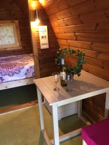 Habitación pequeña con mesa con copas de vino y cama en Glamping at Treegrove, en Kilkenny