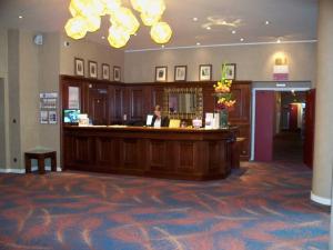 une femme assise dans un bar du hall de l'hôtel dans l'établissement Best Western Hôtel Hermitage, à Montreuil-sur-Mer