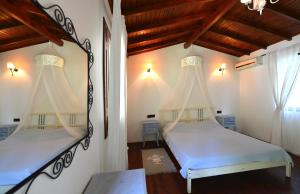 two beds in a room with a mirror at Narcicegi Hotel in Cıralı