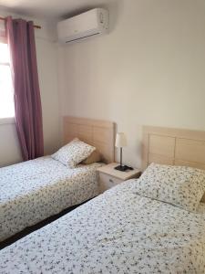 a bedroom with two beds and a window at Casa Pedrada in Zaragoza