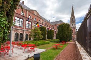 a group of red tables and chairs in front of a building at Best Western Hôtel Hermitage in Montreuil-sur-Mer