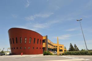 een groot bakstenen gebouw met een gebouw bij The Originals Access, Hôtel Millau Sud (P'tit Dej-Hotel) in LʼHospitalet-du-Larzac