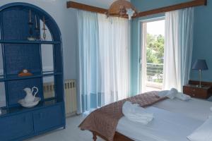 a blue bedroom with a bed and a window at Sunset Beach House in Kato Alepochori