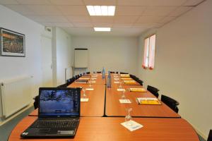 a long table with a laptop on top of it at The Originals Access, Hôtel Millau Sud (P'tit Dej-Hotel) in LʼHospitalet-du-Larzac