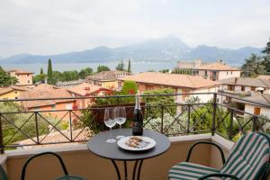 einen Tisch mit zwei Gläsern und eine Flasche Wein auf dem Balkon in der Unterkunft Hotel Pace in Torri del Benaco