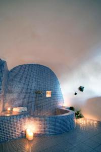 een blauwe betegelde badkamer met een bad in een kamer bij Fotinos Houses in Oia