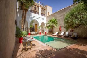 a courtyard with a swimming pool in a building at Riad Charaï in Marrakesh