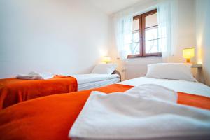 Apartament Mięta في كارباش: سريرين في غرفة باللون البرتقالي والأبيض