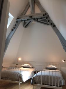 2 łóżka w sypialni na poddaszu z białymi ścianami w obiekcie Les chambres de Marie w Tours