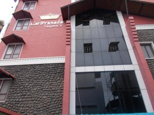 a red building with a sign on the side of it at Hariprasadam in Guruvāyūr