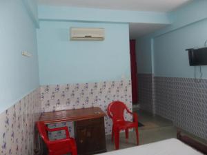 a room with a desk and two red chairs at Hariprasadam in Guruvāyūr