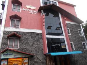 a pink and red building with a store at Hariprasadam in Guruvāyūr