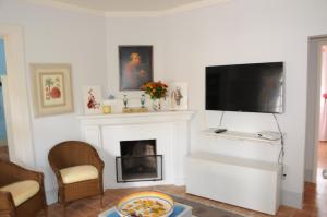a living room with a fireplace and a flat screen tv at Canto das Estrelas in Secretário