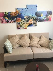 uma sala de estar com um sofá com quatro pinturas na parede em Boracay Oceanway Residences - Island Paradise em Boracay