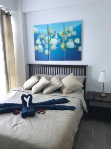 una cama con un animal de peluche azul sentado en ella en Boracay Oceanway Residences - Island Paradise, en Boracay