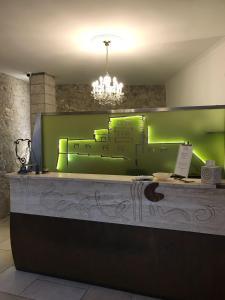 a green wall with a chandelier in a room at Hotel Boutique Il Castellino Relais in Vieste