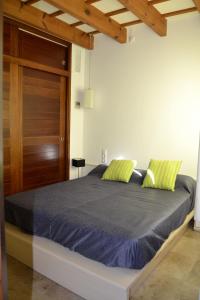 1 dormitorio con 1 cama con sábanas azules y almohadas verdes en Casa Fayas, en Ciutadella