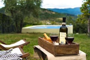 a bottle of wine and two glasses on a table at Sosta al Capitano in Pontassieve