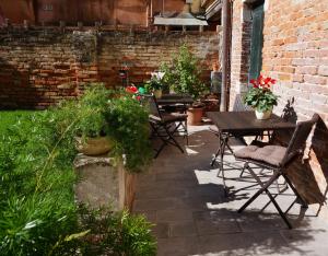 an outdoor patio with tables and chairs and plants at B&B HORTUS in Venice