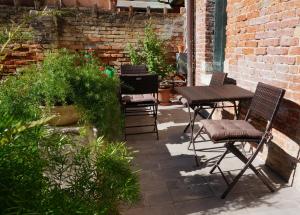 a patio with chairs and a table and some plants at B&B HORTUS in Venice