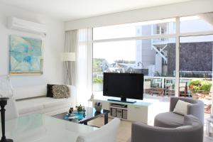 ein Wohnzimmer mit einem großen Fenster und einem TV in der Unterkunft Apartamento Playas Carilo in Carilo