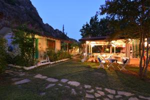 einen Garten mit einem Tisch und Stühlen vor einem Haus in der Unterkunft Narcicegi Hotel in Cıralı