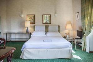 sypialnia z dużym białym łóżkiem i dwoma stołami w obiekcie Aldrovandi Residence City Suites w Rzymie