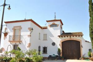 a large white house with a wooden door at Sol Blanc in Alguaire