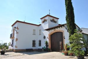 un edificio blanco con una puerta y un árbol en Sol Blanc en Alguaire