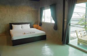 a bedroom with a bed and a large window at B Samcook Home16 in Chiang Mai