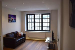 a living room with a couch and a large window at Kings Cross Apartment 5/Apartment in London