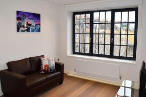 un soggiorno con divano e finestra di Kings Cross Apartment 5/Apartment a Londra