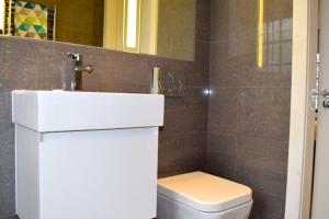 a bathroom with a white sink and a toilet at Kings Cross Apartment 5/Apartment in London