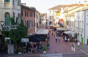 uma rua movimentada da cidade com pessoas a pé e cafés em Alla Torre B&B em Mestre