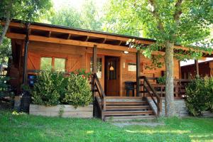 Cabaña con porche y banco en el patio en Bungalows Nou Camping en Guingueta